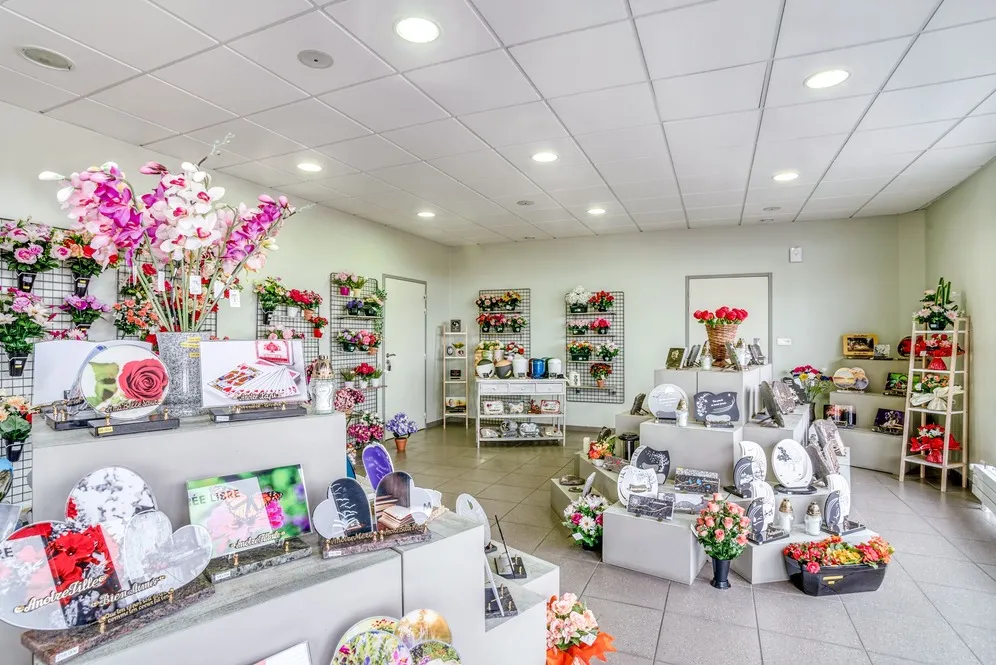 Intérieur du magasin de pompes funèbres présentant l'exposition d'articles commémoratifs et fleurs