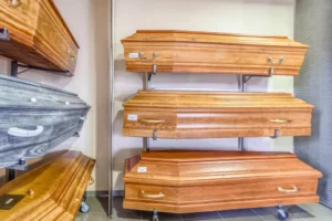 Modèles de cercueils en bois massif et teintes variées exposés sur des supports muraux